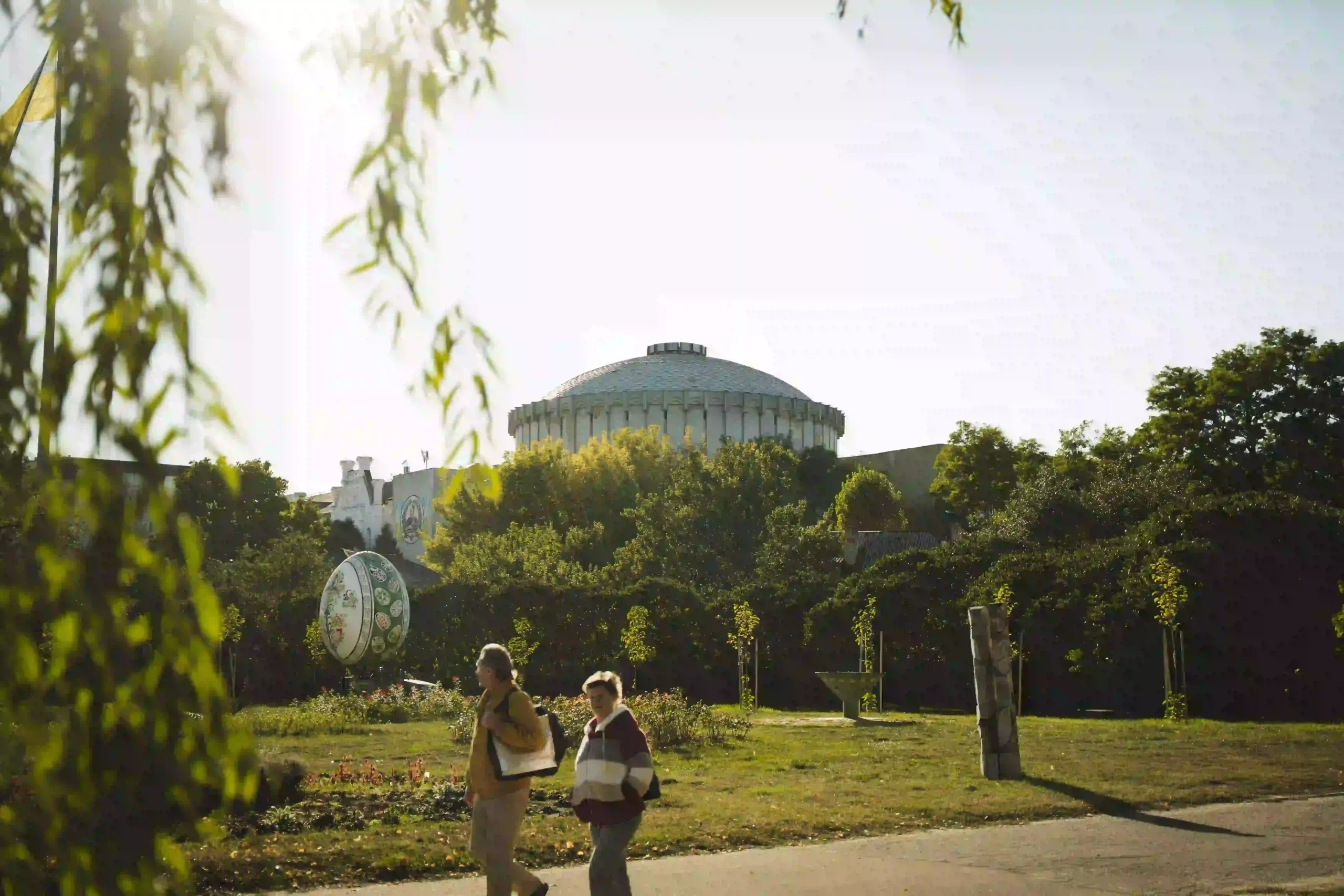 Вид на округлий купол з вулиці Героїв Сумщини прикрашають крони дерев.